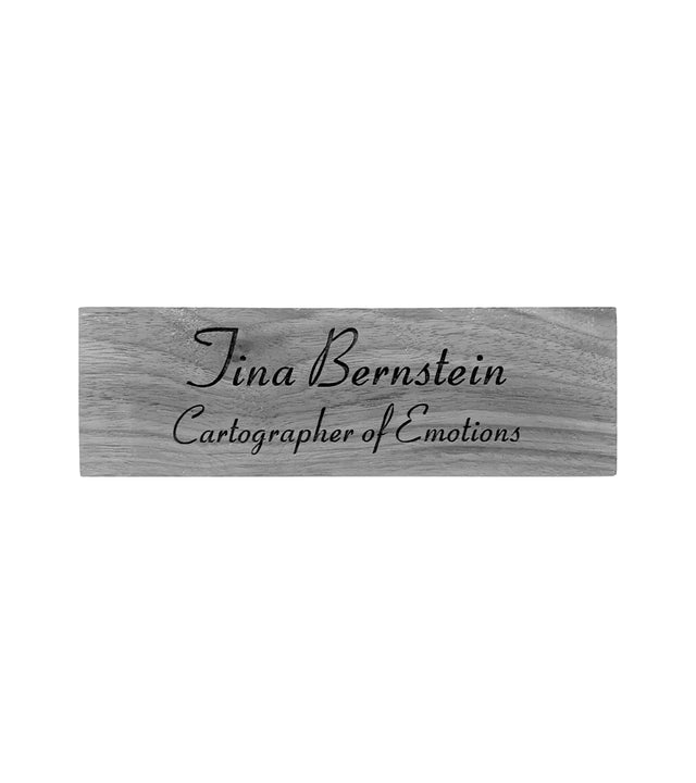 a wooden desk sign with the name of Tina Bernstein  adn Cartographer of Emotions engraved